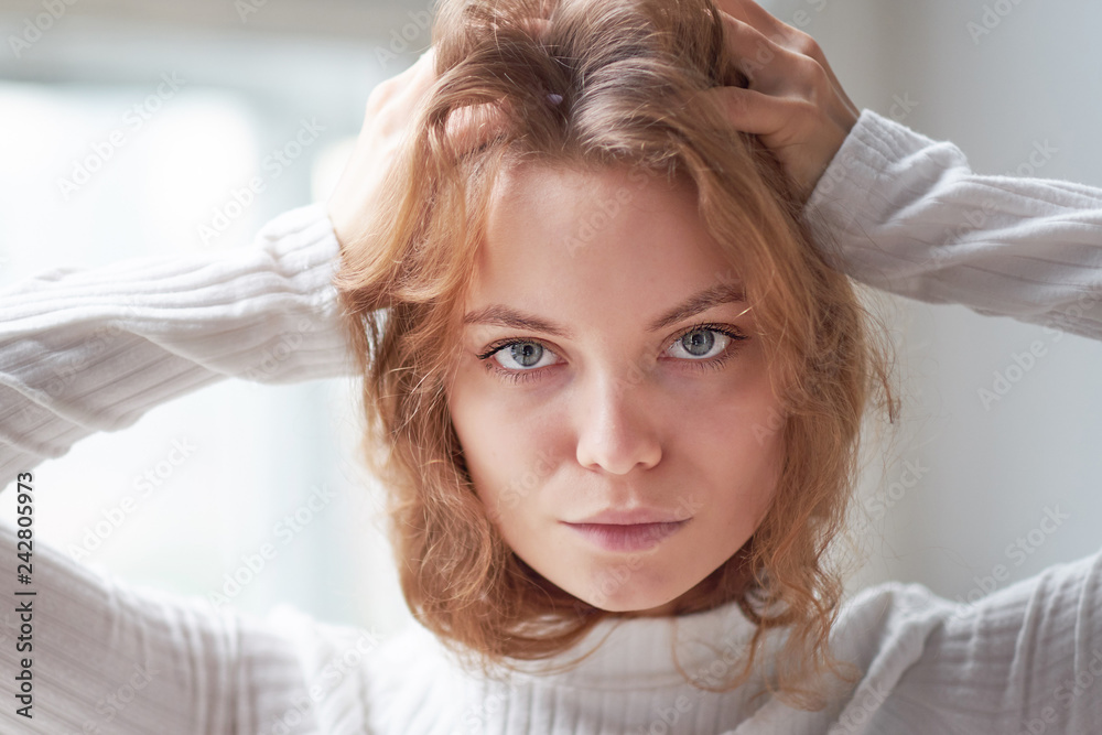 Fototapeta premium portrait of a beautiful curly girl. the mysterious face of a woman at the window.