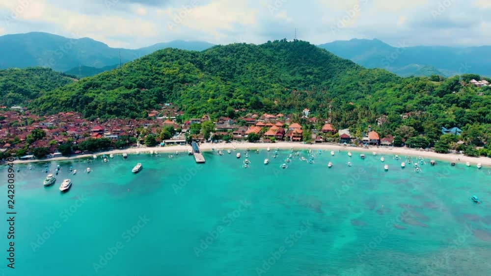 Yacht and tourist boat on the blue sea water in a tropical lagoon near the coastline on which there are buildings and road. Summer vacation and travelling concept Yacht and tourist boat on the blue sea water in a tropical lagoon near the coastline on which there are buildings and road. Summer vacation and travelling concept