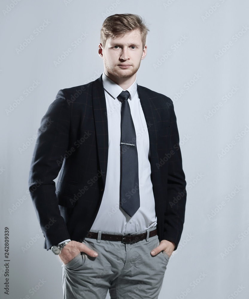 Fototapeta premium creative business man stands with his hands in his pockets.isolated on grey background