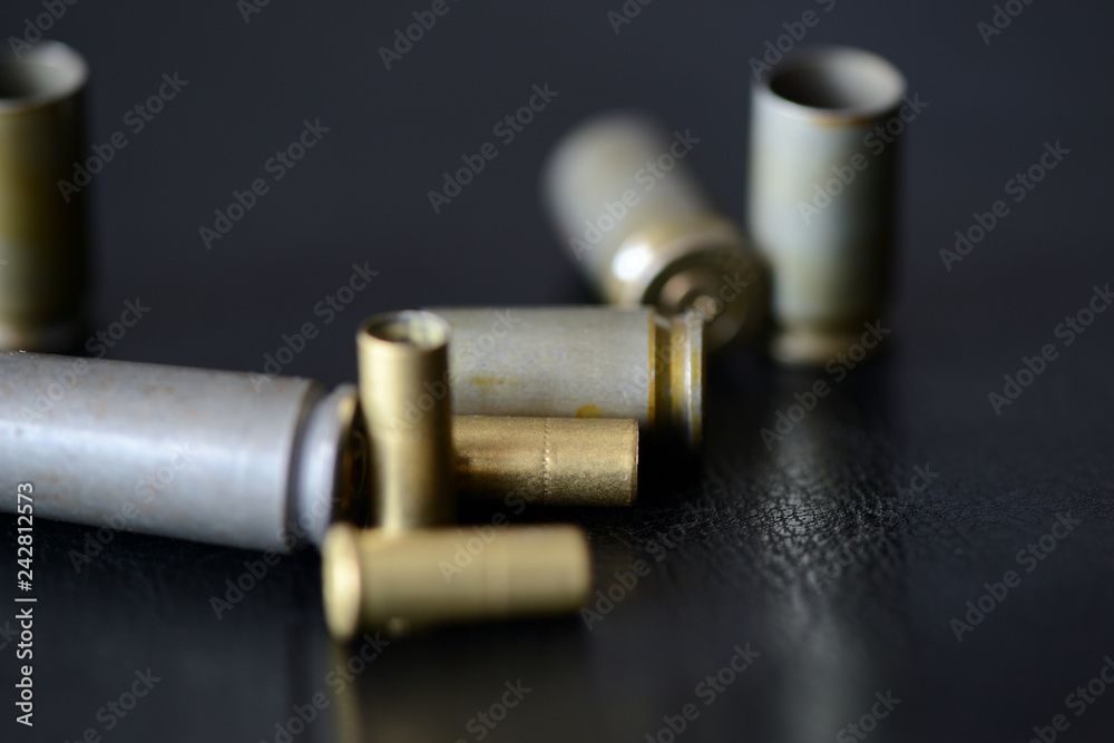 Empty old bullet cartridges on a dark background close up Empty old bullet cartridges on a dark background close up