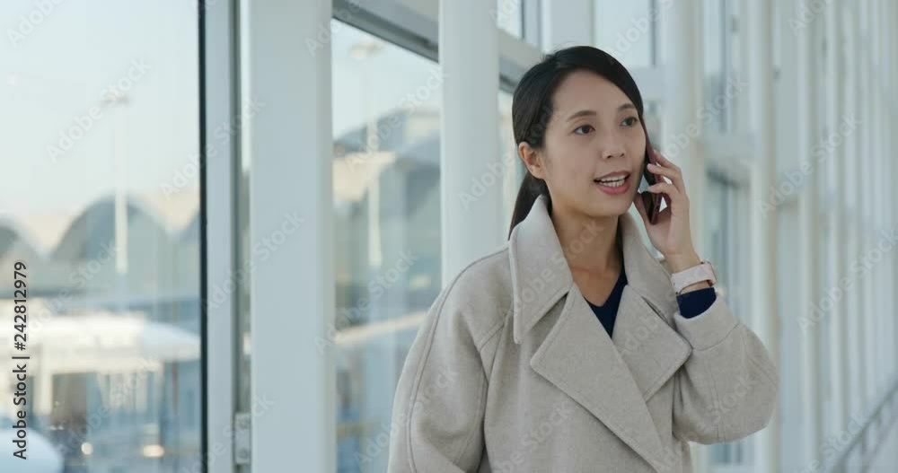 Businesswoman talk to cellphone in the airport Businesswoman talk to cellphone in the airport