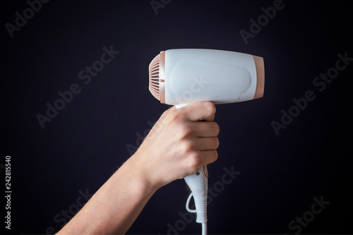 person hold white hair dryer in his hand isolated b