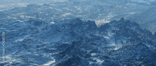 Aerial of rough bare mountains with snow at sunrise.