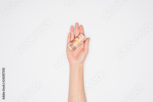 partial view of woman holding money roll in open palm isolated on grey