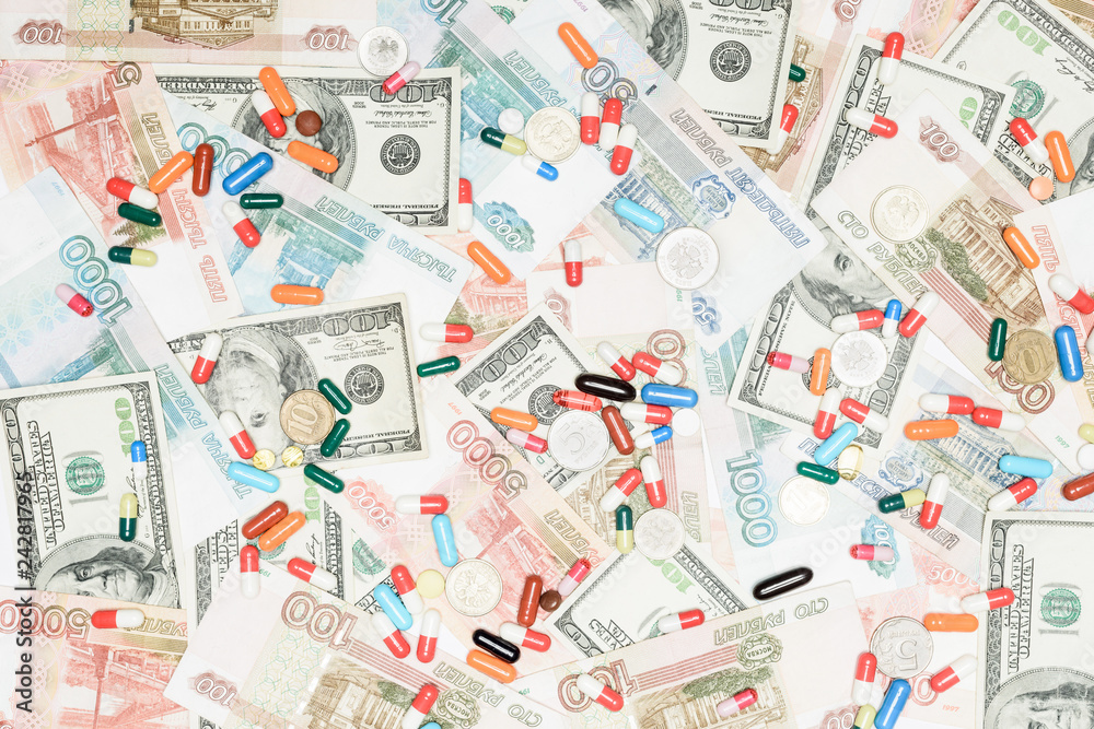 top view of multicolored pills and coins on rubles and dollars background top view of multicolored pills and coins on rubles and dollars background