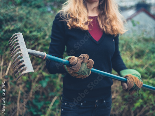 Young woman with rake in garden photo