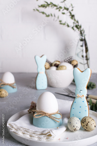Homemade easter cookies in the shape of  a  funny  bunny, quail eggs  and chicken egg. Easter  celebration table setting. Holiday decorations.