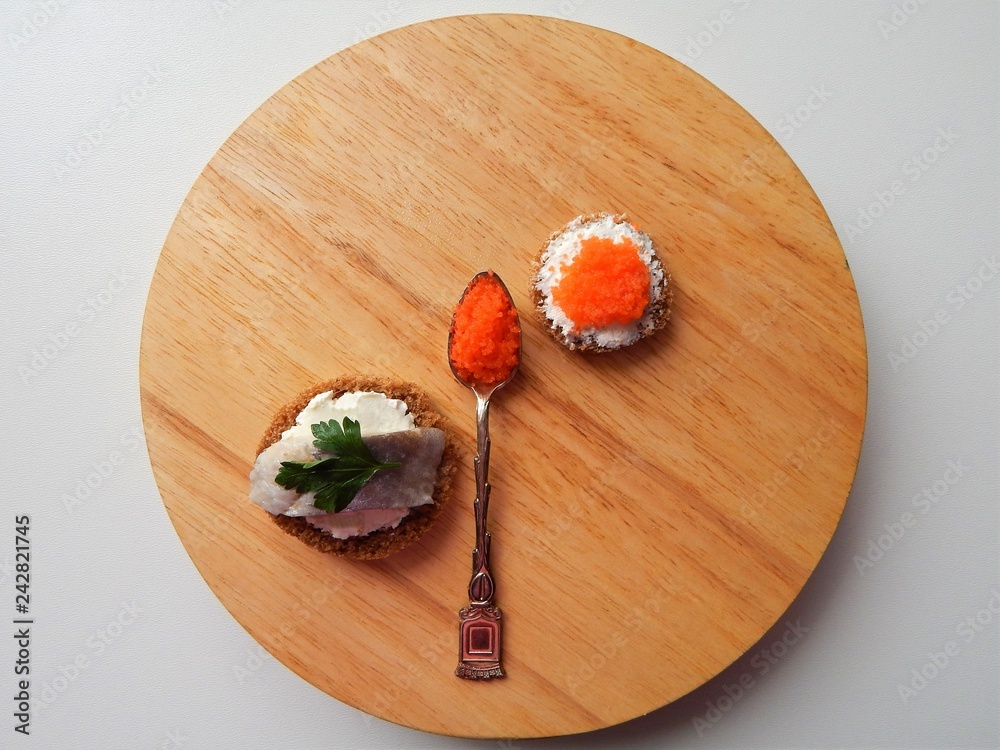 Elegant canapes with cream cheese, herring and flying fish caviar and flying fish caviar in vintage spoon Elegant canapes with cream cheese, herring and flying fish caviar and flying fish caviar in vintage spoon
