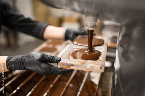 Bilde på lerret production, cooking and people concept - confectioner filling candy mold with ch