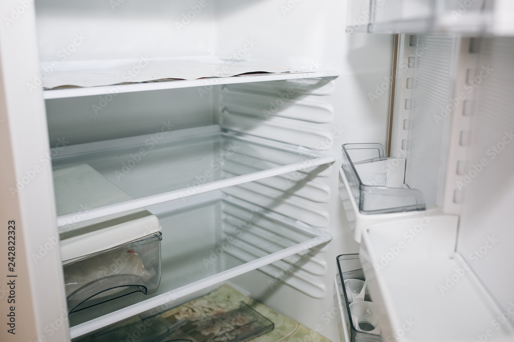 New empty fridge inside. White shelves for food and products. New empty fridge inside. White shelves for food and products.