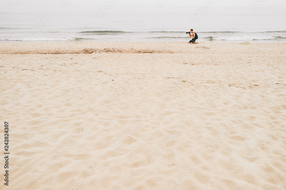 Alone traveler holding a camera , holiday on the beach