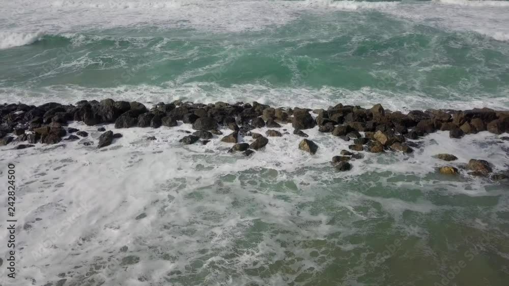 Massive Storm waves hitting and passing a wave breaker - Tsunami pattern of sea water flooding and not retreating. Massive Storm waves hitting and passing a wave breaker - Tsunami pattern of sea water flooding and not retreating.