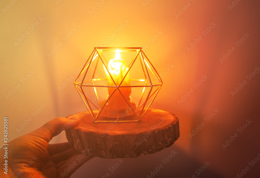 Hand made bee wax candle in a candleholder on wooden slice. Hand made bee wax candle in a candleholder on wooden slice.