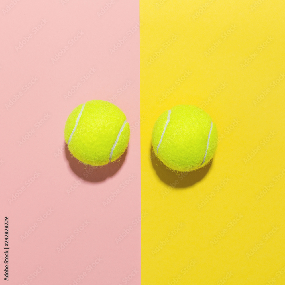 Tennis balls flat lay on pink and yellow