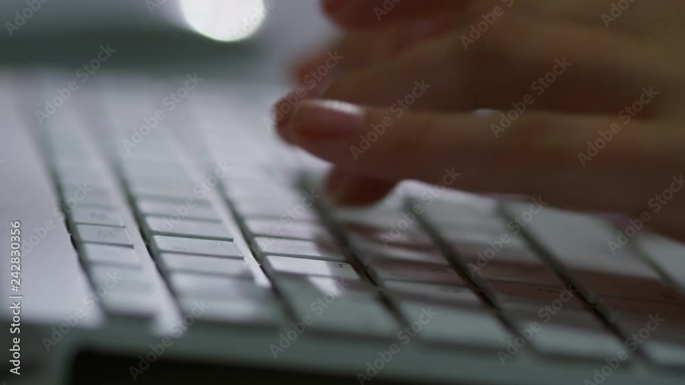 Extreme close up tracking shot of hands of unrecognizable male employee typing on desktop computer keyboard