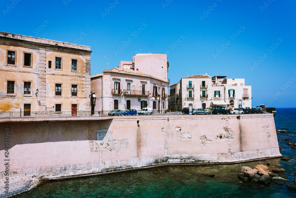 Obraz premium View of old street, facades of ancient buildings in seafront of Ortygia (Ortigia) Island, Syracuse, Sicily, Italy.