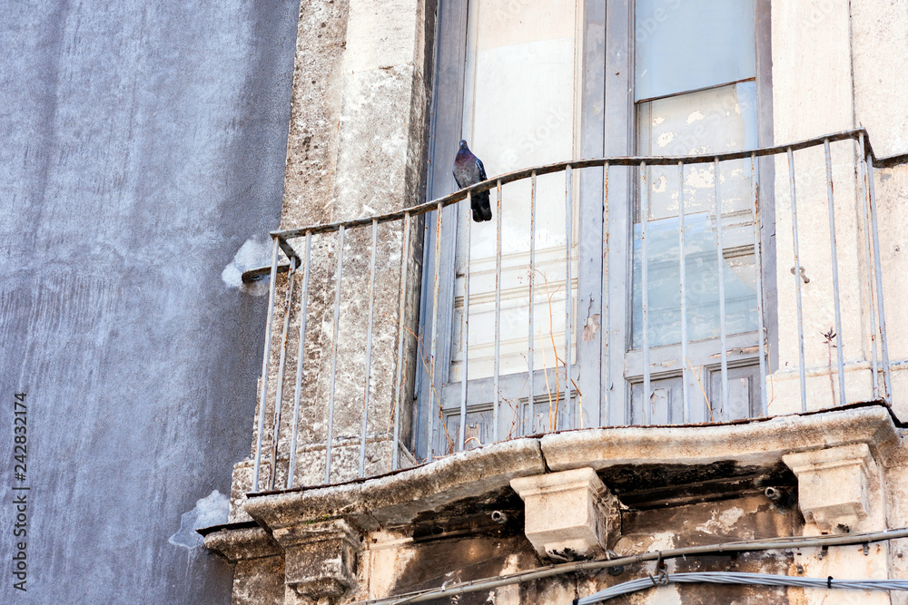 Balcony in a historic building in Catania, traditional architecture of Sicily, Italy.