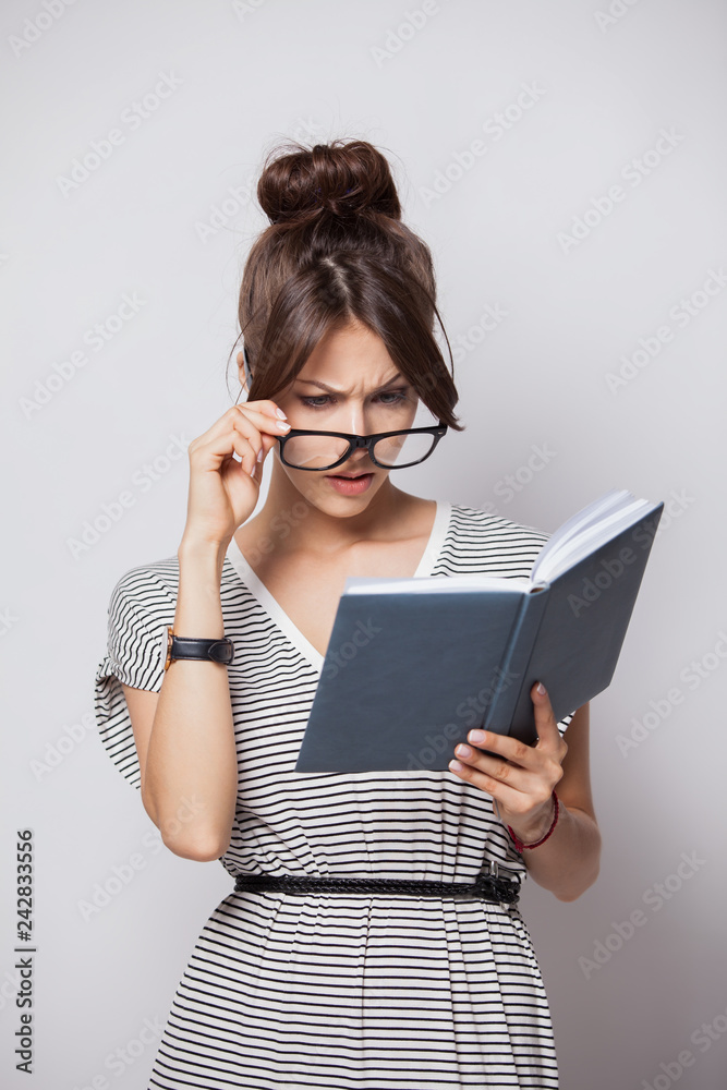 young happy businesswoman makes some notes in notepad, isolated on white.