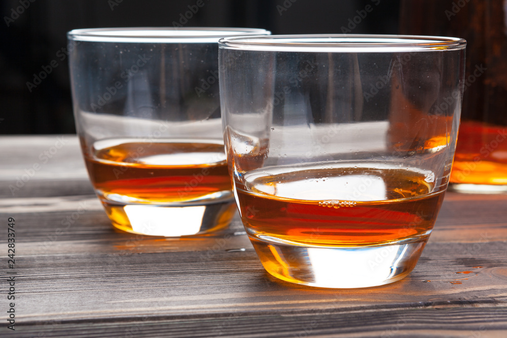 whiskey with ice cubes on wooden background whiskey with ice cubes on wooden background