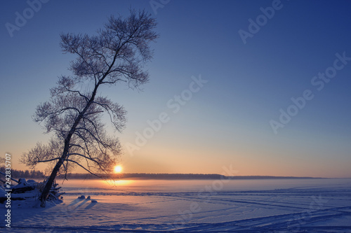 Sunset on a frozen lake. Winter landscape.