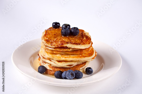 Pancakes with berries and honey on the white background