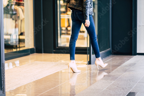 Fashion woman walking in stretch skinny jeans outside a store after shopping activity in the city - mall concept for lady with slim legs and fashion style