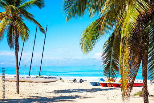 Fototapeta Naklejka Na Ścianę i Meble -  The tropical beach of Varadero in Cuba with sailboats and palm trees on a summer day with turquoise water. Vacation background.