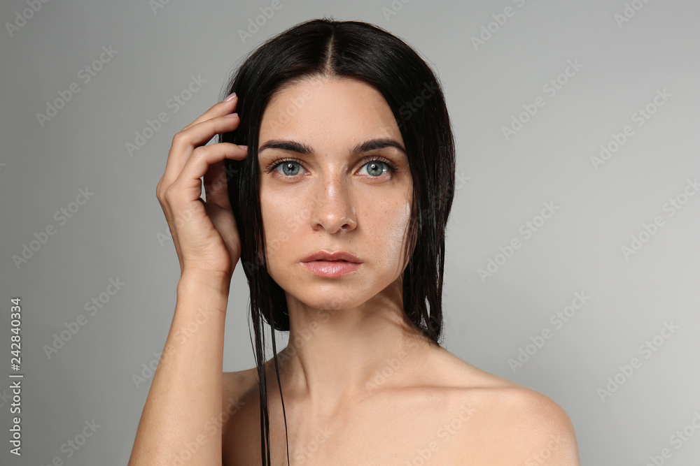 Portrait of beautiful young woman with natural makeup on grey background Portrait of beautiful young woman with natural makeup on grey background