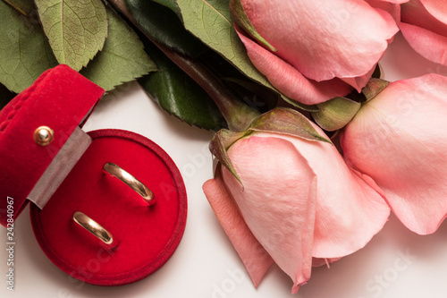 Box with wedding rings and bouquets of pink roses photo