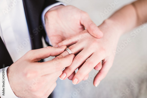 the bridegroom puts on a wedding engagement ring to the bride on finger