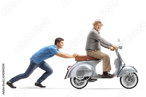 Young guy pushing an elderly man on a vintage scooter