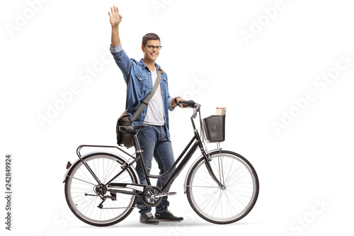Casual young man with a bicycle waving