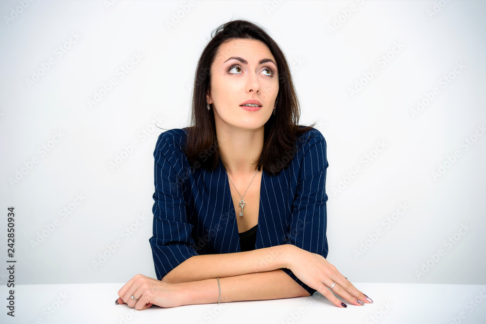 Concept beautiful business woman secretary manager on a white background sitting at a table in various poses right in front of the camera. She works with documents with different emotions.