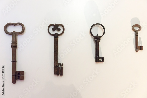 Four old rusty keys on the bright house wall © kelifamily