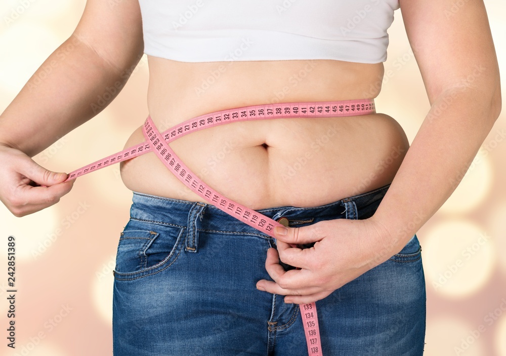 Fototapeta premium Close-up female figure with measuring tape on grey background
