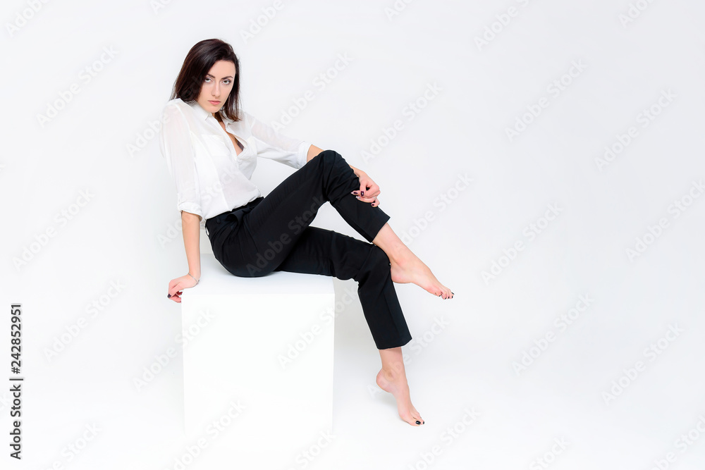 Concept portrait of a girl sitting on a white background in a business suit in different poses with different emotions. It in the middle of the frame, next to the white cubes, next is another cube. Concept portrait of a girl sitting on a white background in a business suit in different poses with different emotions. It in the middle of the frame, next to the white cubes, next is another cube.