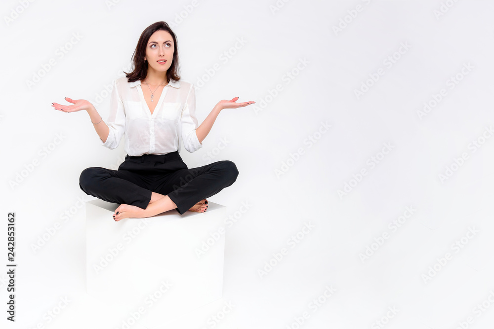 Concept portrait of a girl sitting on a white background in a business suit in different poses with different emotions. It in the middle of the frame, next to the white cubes, next is another cube. Concept portrait of a girl sitting on a white background in a business suit in different poses with different emotions. It in the middle of the frame, next to the white cubes, next is another cube.