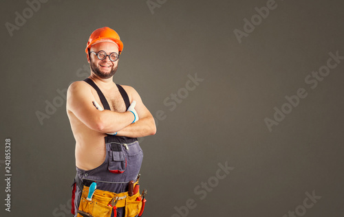 Funny fat bearded builder smiling on background for text.