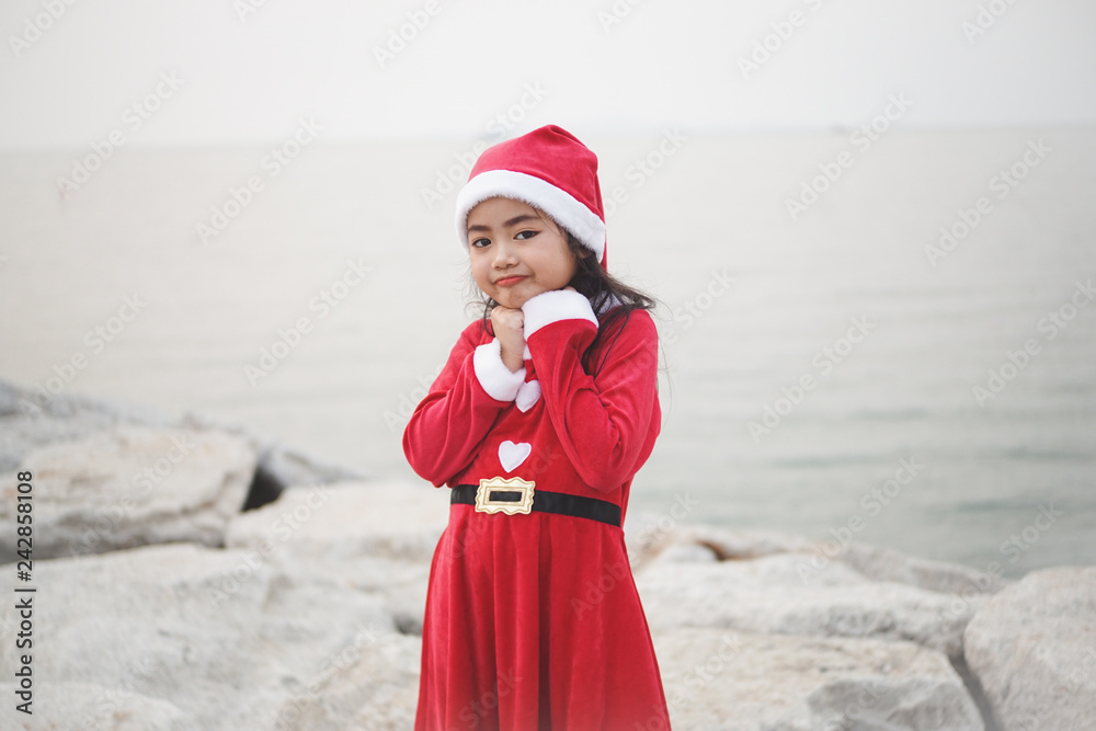 Obraz premium Little Asian girl in Santa Claus dress.Be smiling and played with camera.