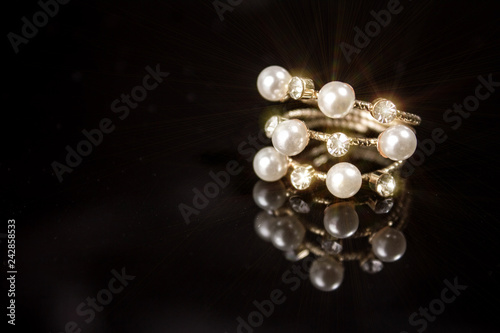 ring with pearls and diamonds on black background