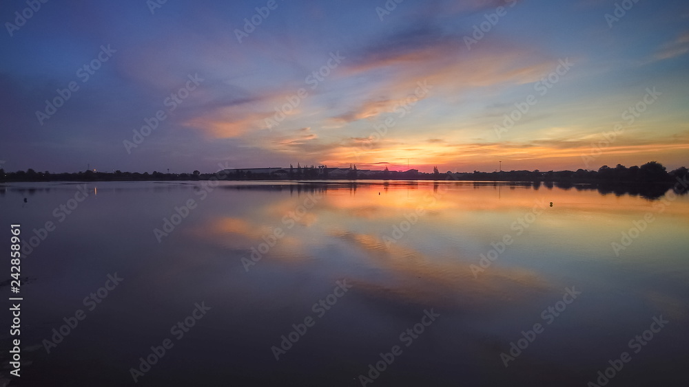 Top view evening above the lake, beautiful vivid red sky and reflection on the surface of water, sunset at Krajub reservoir, Banpong District, Ratchaburi, western of Thailand.