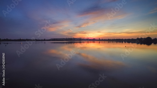 Top view evening above the lake, beautiful vivid red sky and reflection on the surface of water, sunset at Krajub reservoir, Banpong District, Ratchaburi, western of Thailand. © Yuttana Joe