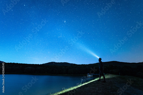 Night sky with stars and silhouette of a man.