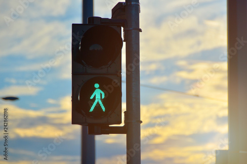 Φωτογραφία Green semaphore pedestrian light close-up. Sunset in background.