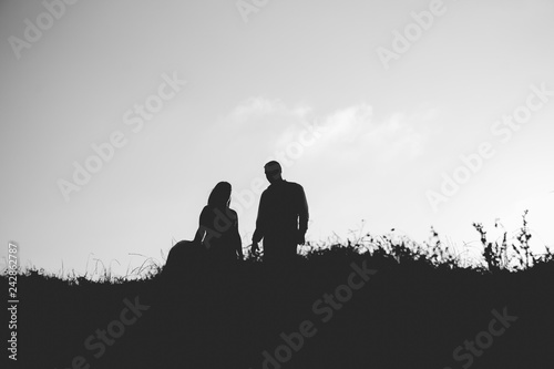 Silhouette of couple in love with wedding couple on top of a hill