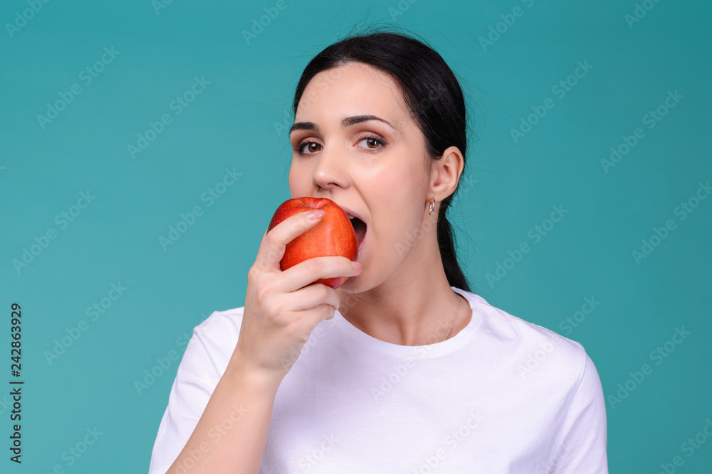 Beautiful young attractive european woman eating fresh red apple. Healthy lifestyle concept. Raw vegetarian organic food. Beautiful young attractive european woman eating fresh red apple. Healthy lifestyle concept. Raw vegetarian organic food.