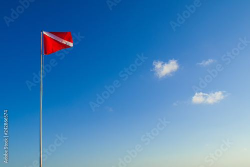 The divers down flag is the internationally recognized notification that there are divers in the water. This one has been shot against a clear blue sky in a topical location 