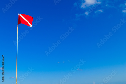 The divers down flag is the internationally recognized notification that there are divers in the water. This one has been shot against a clear blue sky in a topical location 