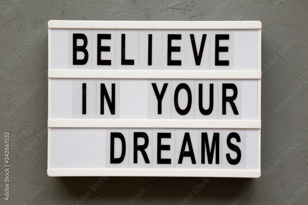 Lightbox with text 'Believe in your dreams' over concrete background, top view. From above, overhead, flat lay. Lightbox with text 'Believe in your dreams' over concrete background, top view. From above, overhead, flat lay.
