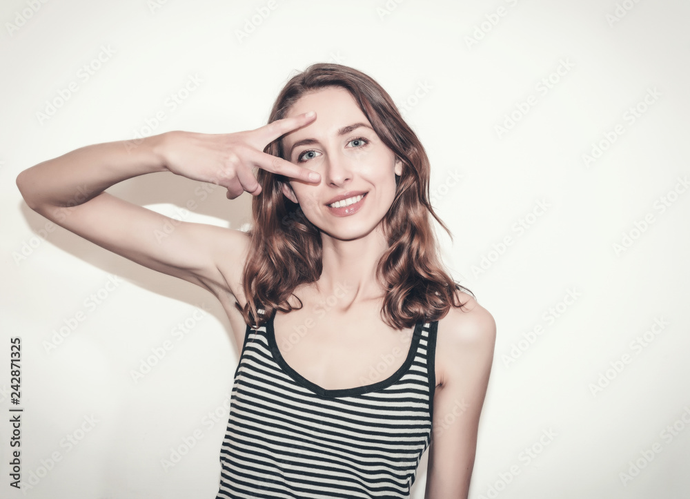 Nice girl in a striped T-shirt. Fingers gesture v Nice girl in a striped T-shirt. Fingers gesture v